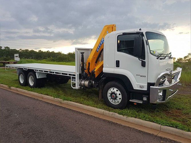 A White Truck With a Yellow Crane on the Back is Parked on the Side of the Road — Roll Press NT In Tivendale, NT