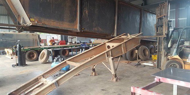 A Large Metal Structure is Sitting in a Garage Next to a Forklift — Roll Press NT In Tivendale, NT