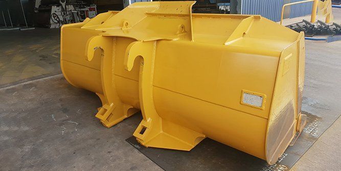 A Yellow Bucket is Sitting on the Ground in a Garage — Roll Press NT In Tivendale, NT