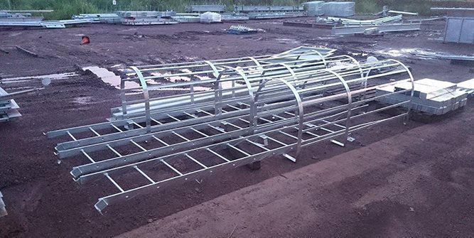 A Bunch of Metal Ladders Are Sitting on Top of a Dirt Field — Roll Press NT In Tivendale, NT