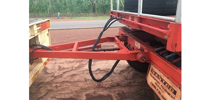 A Red Truck With a Trailer Attached to It is Parked on the Side of the Road — Roll Press NT In Tivendale, NT
