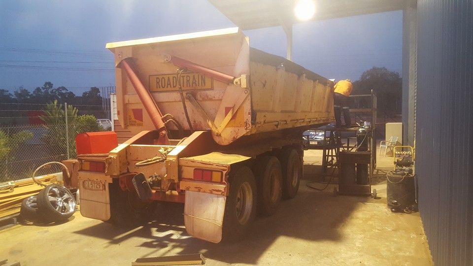 A Dump Truck is Parked in a Garage at Night — Roll Press NT In Berrimah, NT