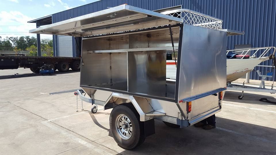 A Stainless Steel Trailer is Parked in a Parking Lot in Front of a Building — Roll Press NT In Berrimah, NT