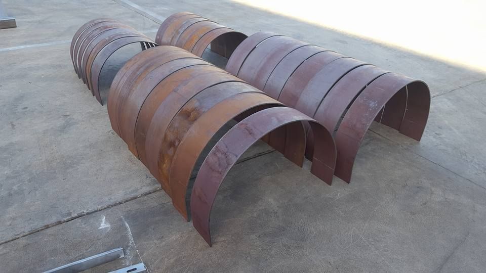 A Bunch of Rusty Metal Pipes Are Sitting on the Ground — Roll Press NT In Berrimah, NT