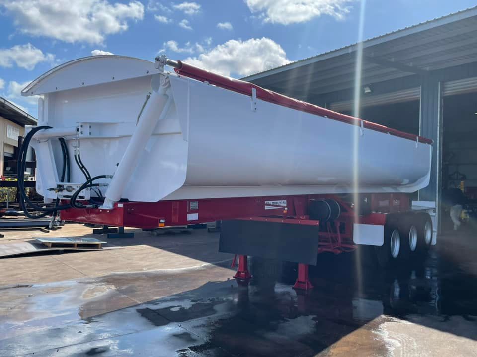 A White and Red Dump Truck is Parked in Front of a Building — Roll Press NT In Tivendale, NT