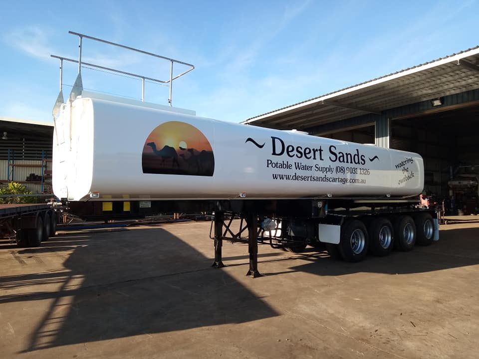 A Desert Sands Trailer is Parked in Front of a Building — Roll Press NT In Tivendale, NT