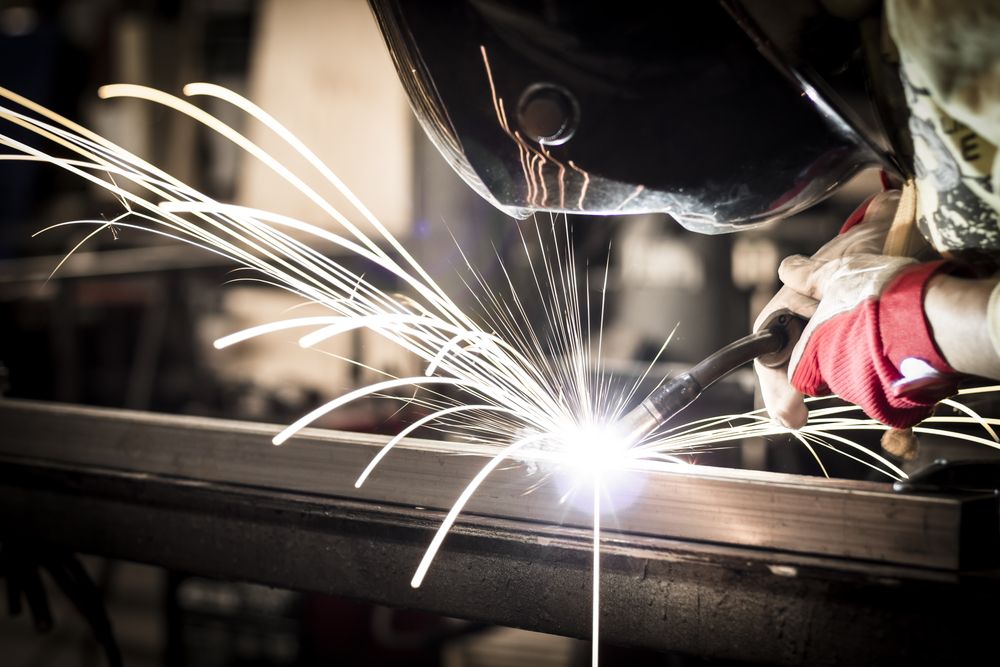 Welder working on a piece of metal - Roll Press NT Pty Ltd