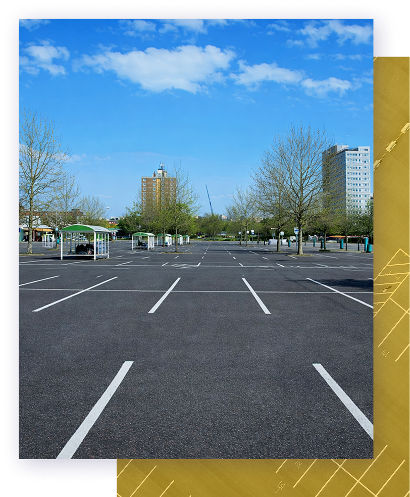 Empty asphalt road with modern office buildings, trees, and blue sky.