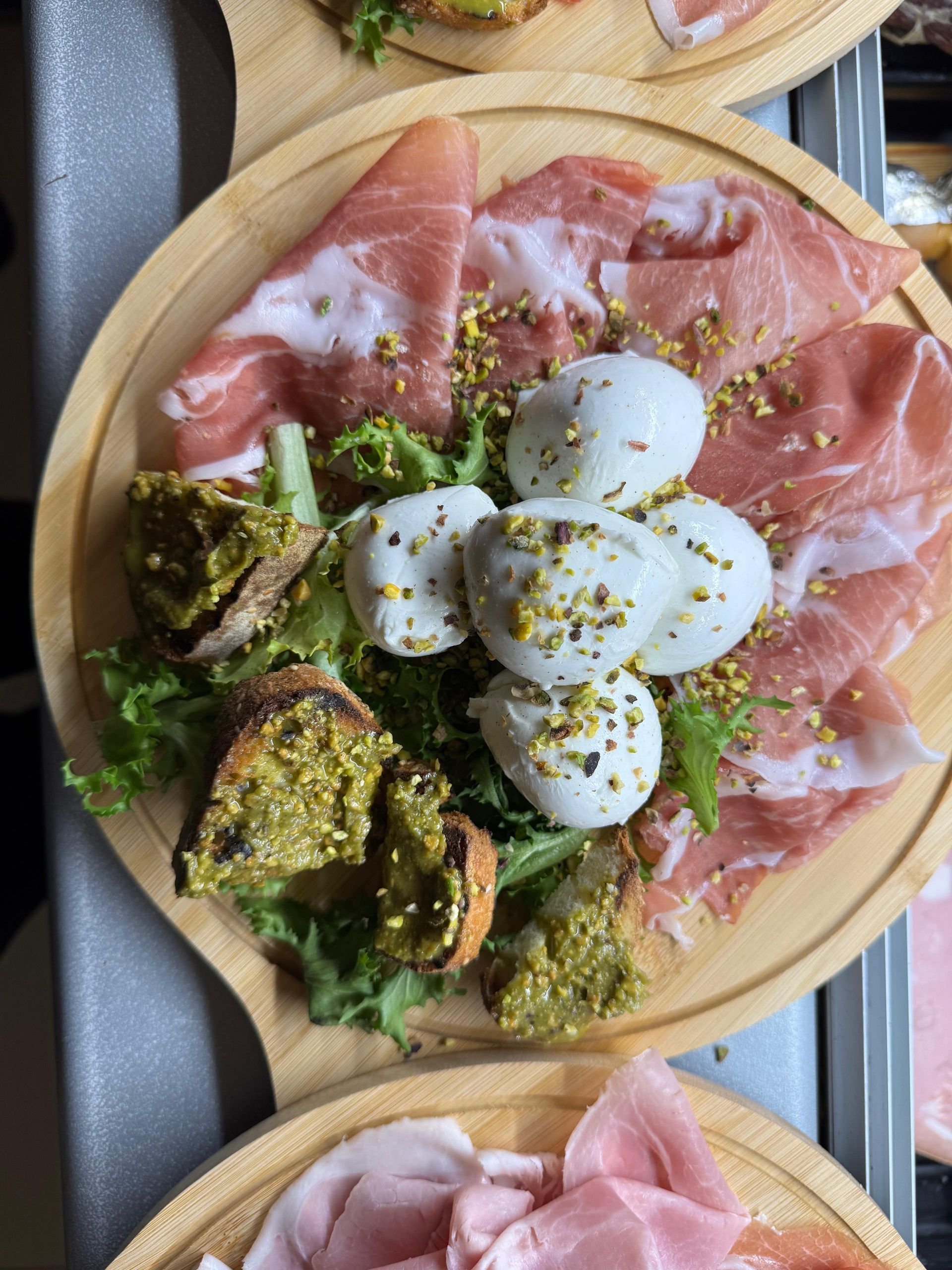 Un tagliere di legno con carne e verdure sopra