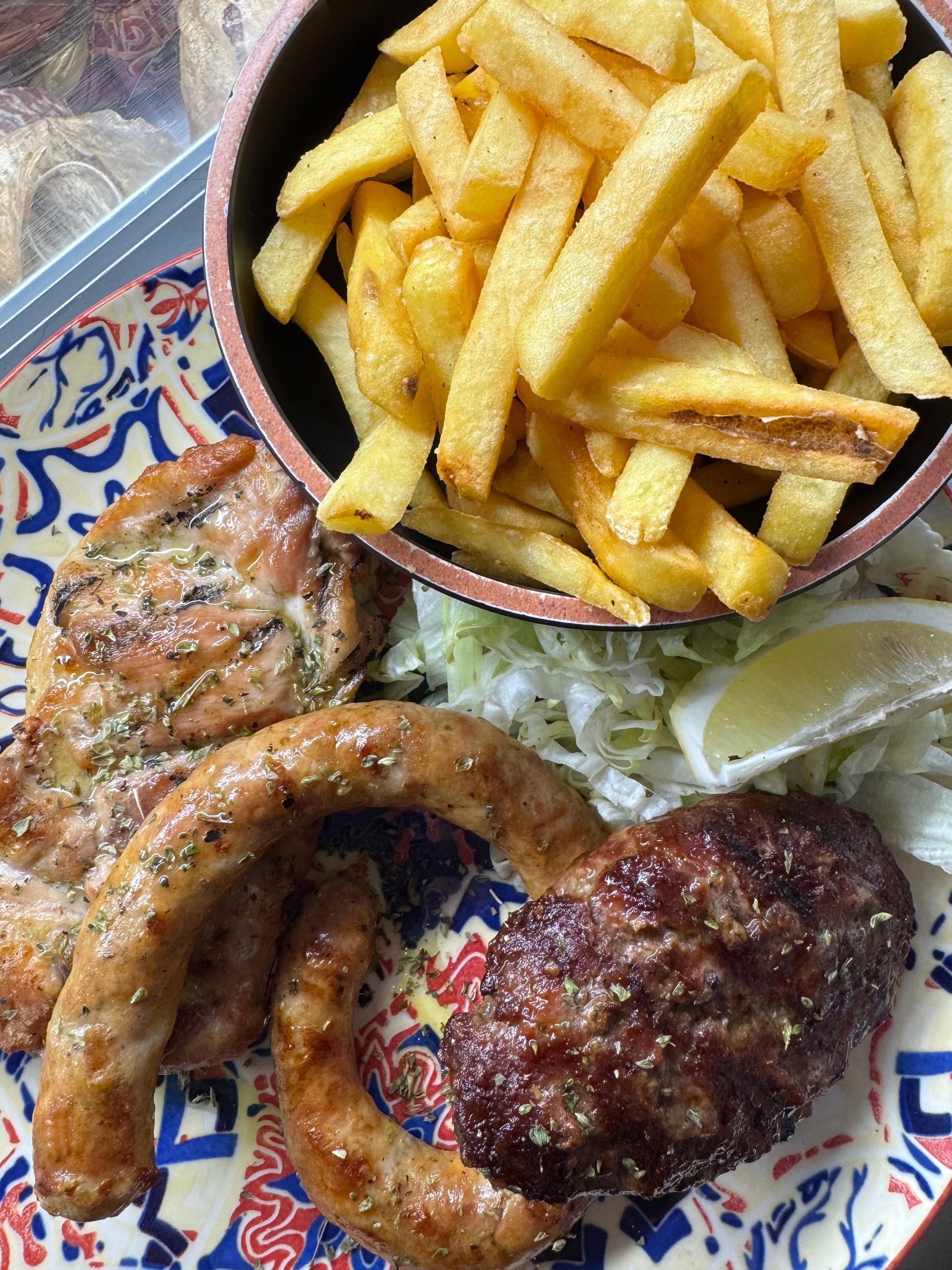Un primo piano di un piatto di cibo con patatine fritte e carne.