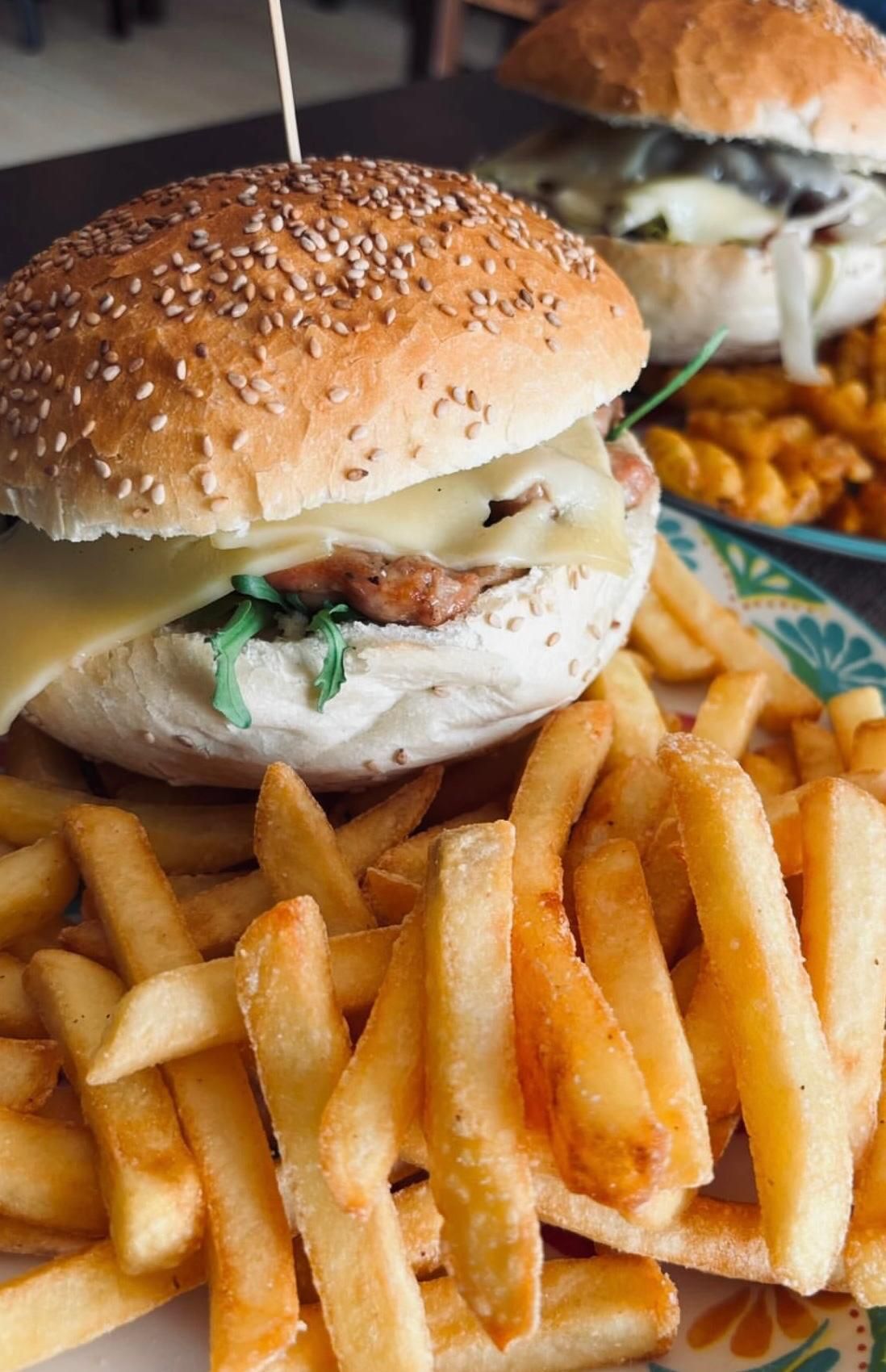 Un hamburger e patatine fritte su un piatto su un tavolo.
