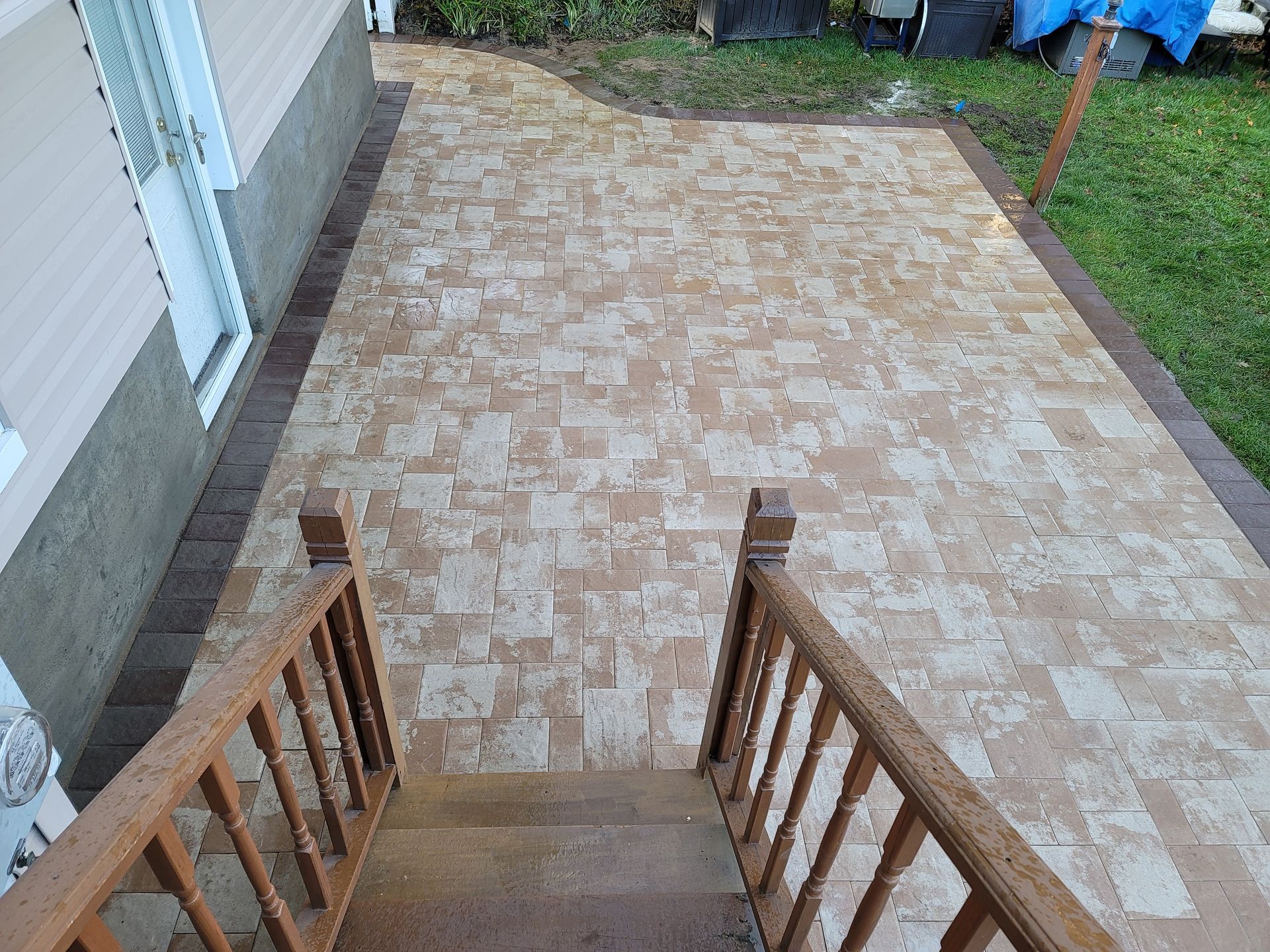 A patio with stairs leading up to it and a wooden railing.