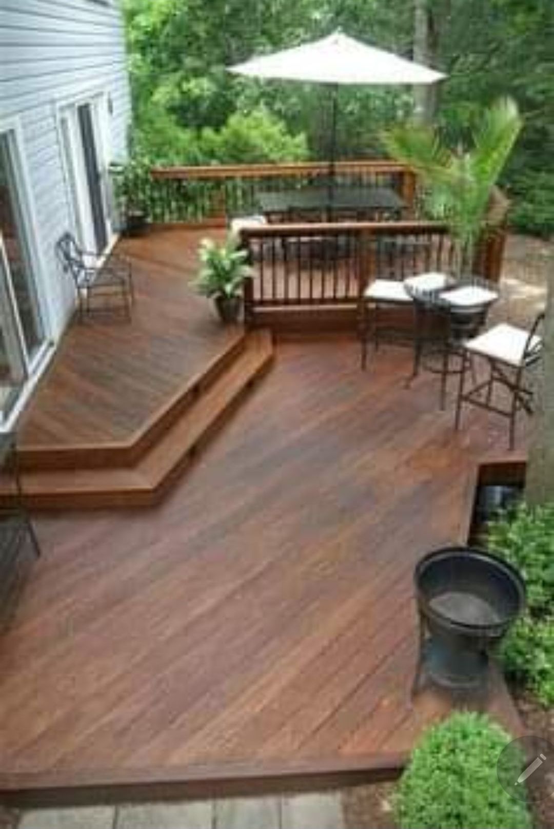 A wooden deck with a table and chairs and an umbrella.