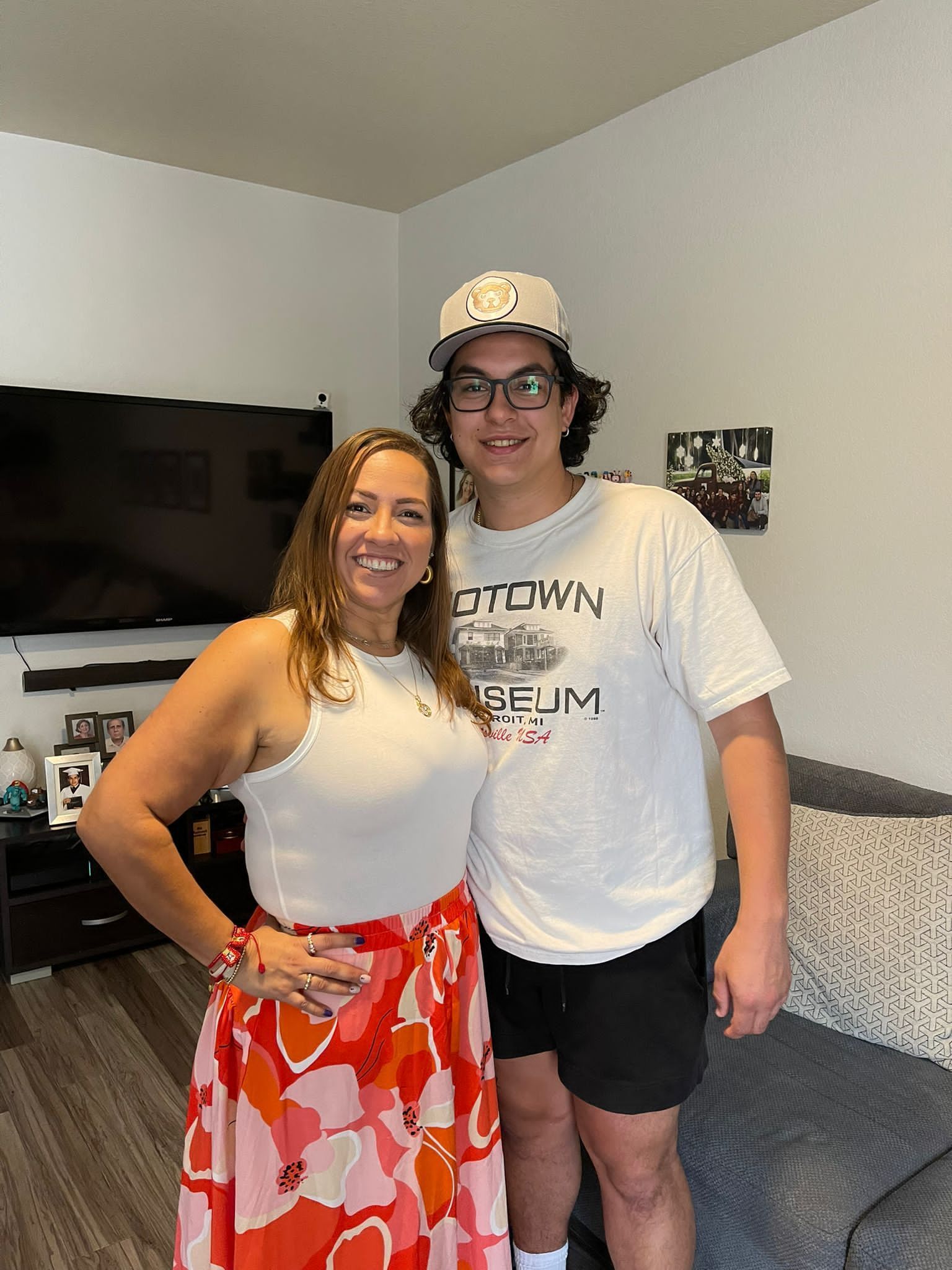 A man and a woman are posing for a picture in a living room.