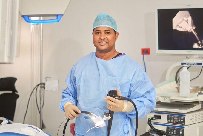 A surgeon is holding an endoscope in an operating room.
