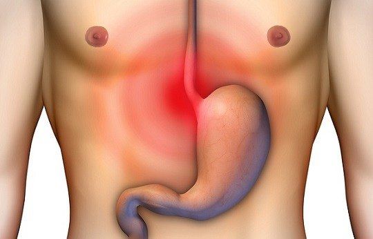 A man 's stomach is shown with a red spot on it.