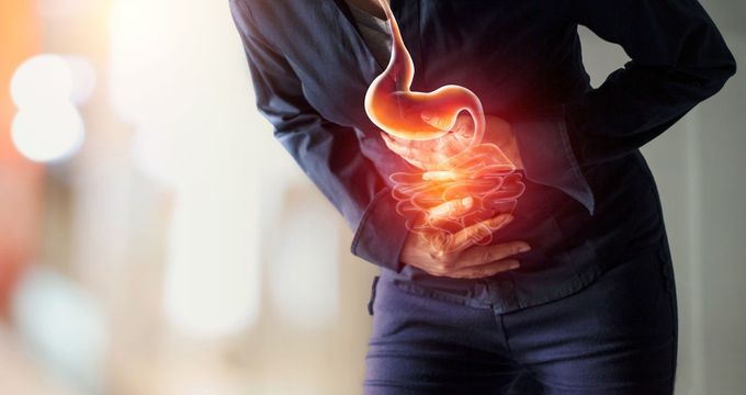 A woman is holding her stomach in pain.