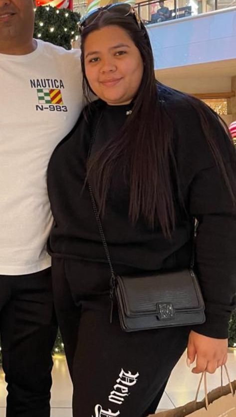 A woman is posing for a picture with a man in a nautica shirt.