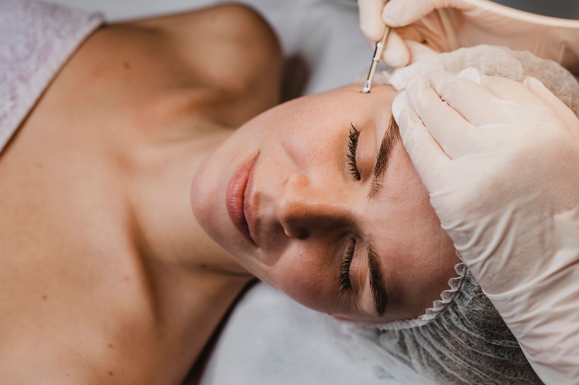A woman is getting a facial treatment at a beauty salon.