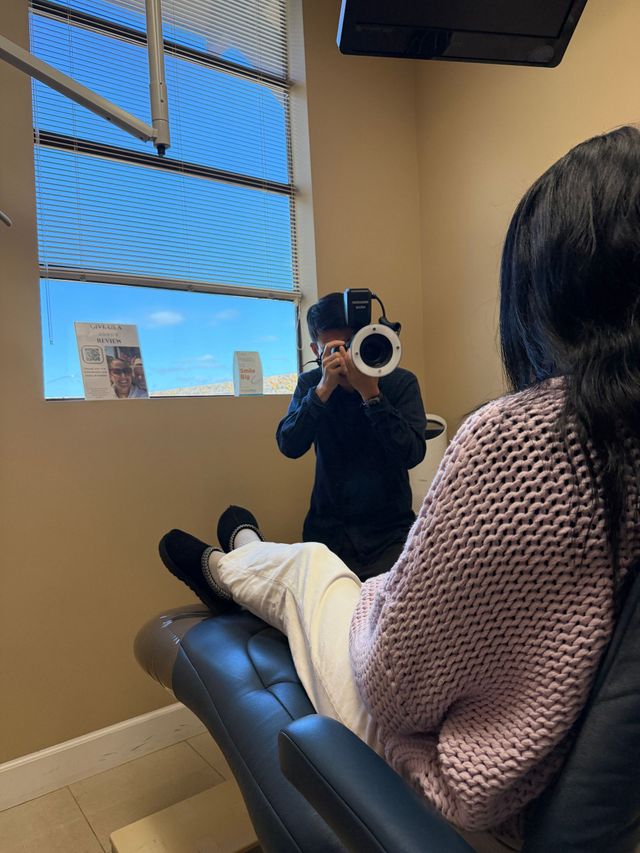 Woman undergoing a dental X-ray with a technician adjusting the machine