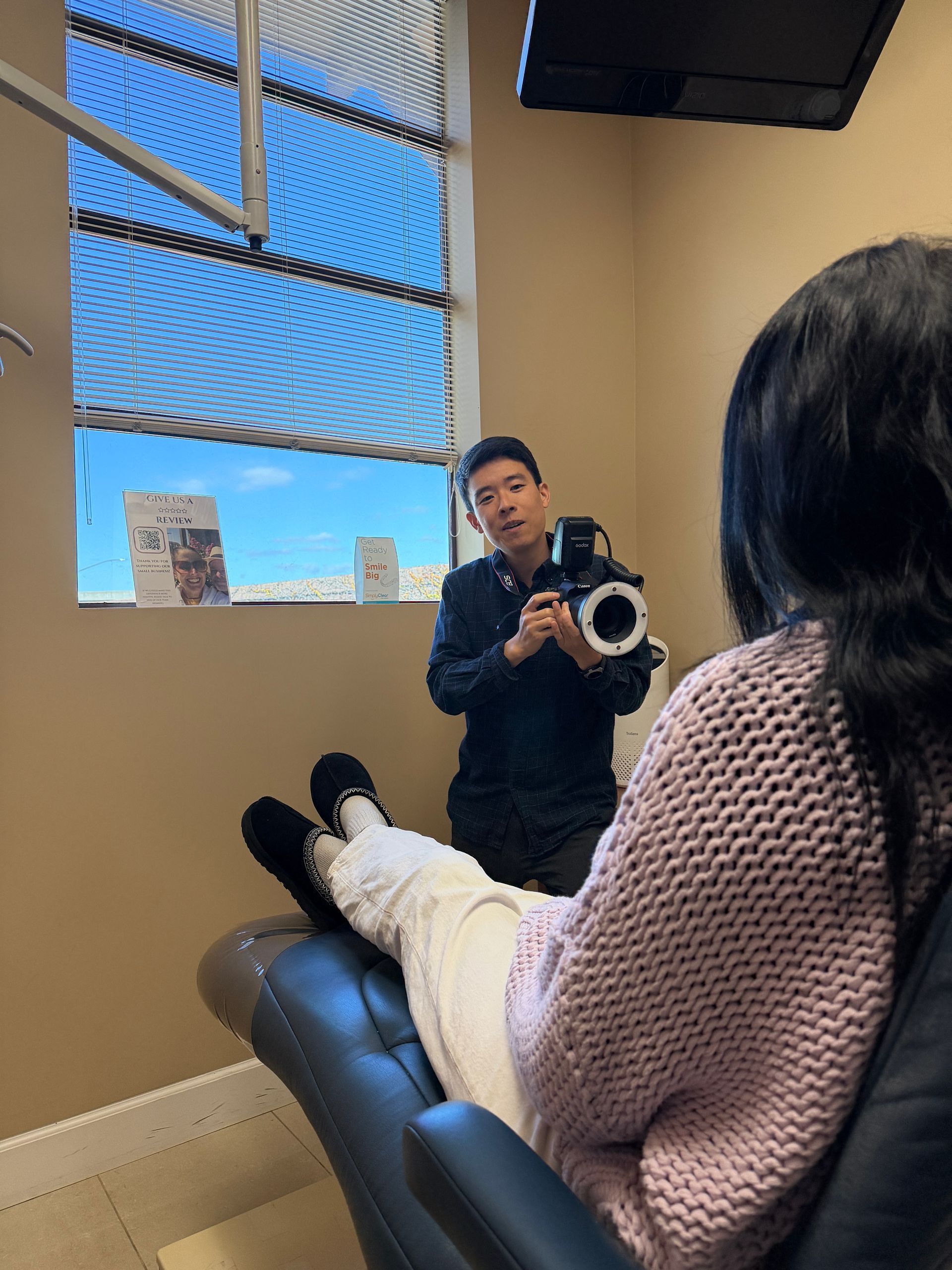 Gloved hands adjusting clear braces on a patient’s open mouth