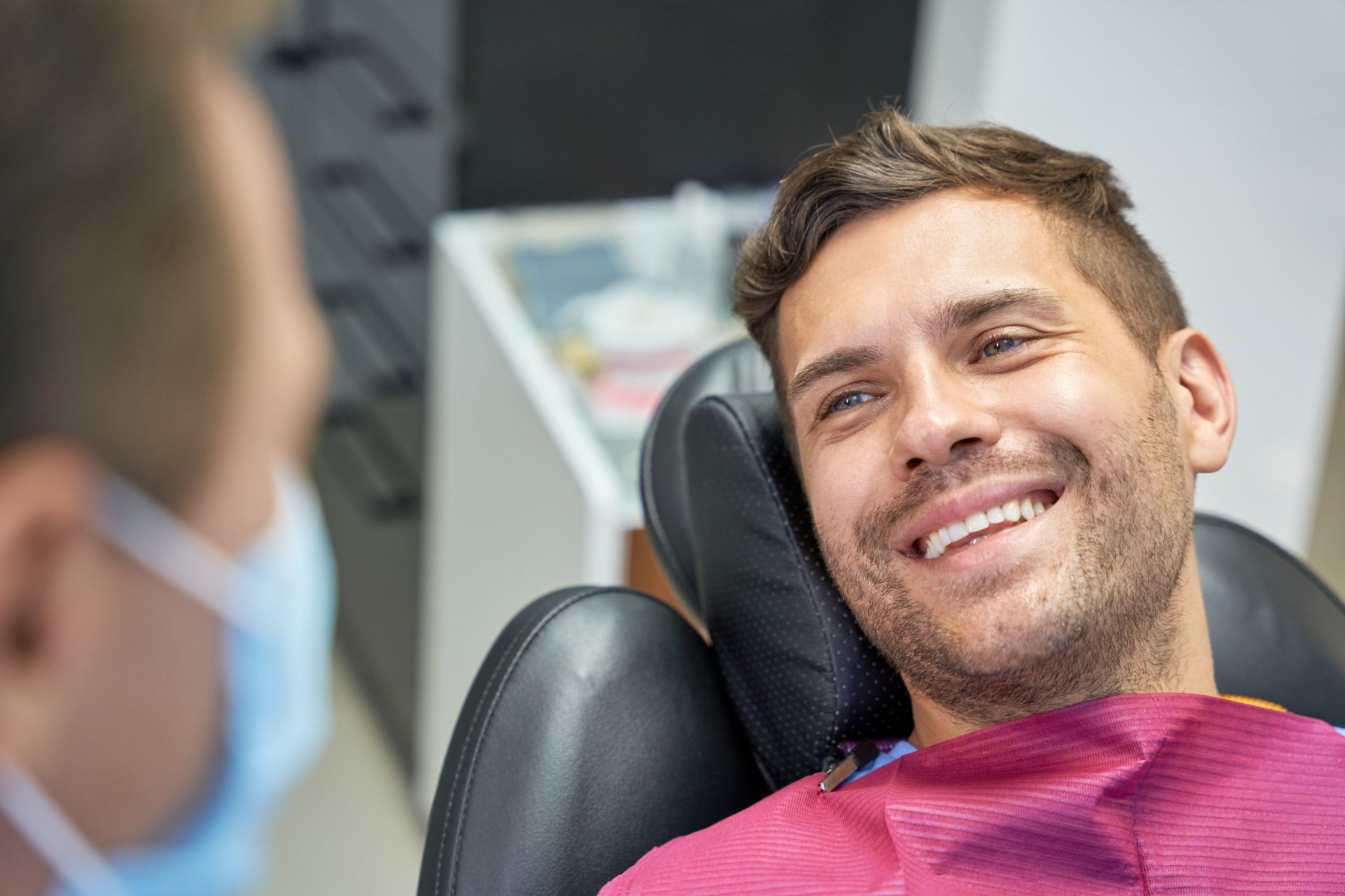 Smiling patient reclining in a dental chair during a checkup
