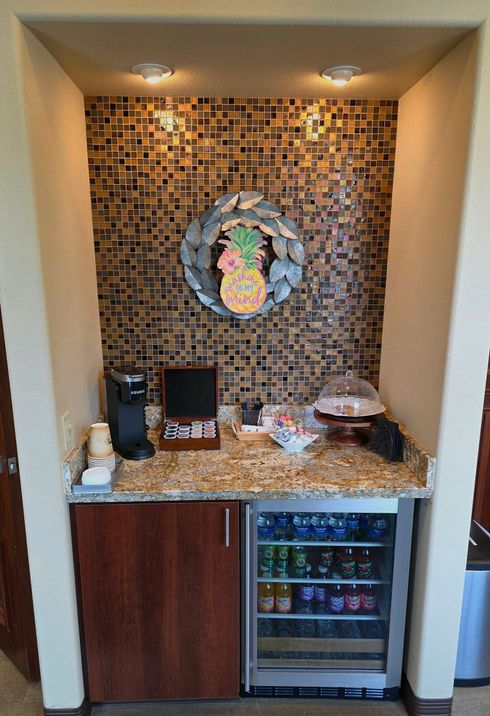 Reception area with a curved granite countertop, a dark wooden base, and a sign that reads 
