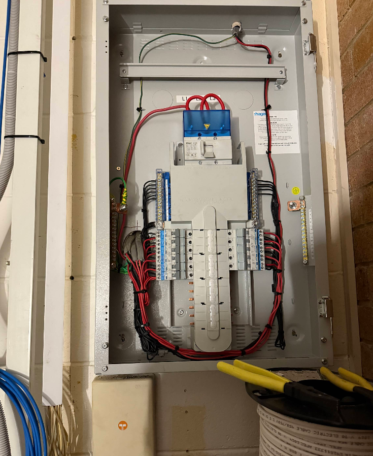 Open Electrical Panel With Wires and Circuit Breakers Mounted on a Wall — CDT Electrical in Lennox Head, NSW
