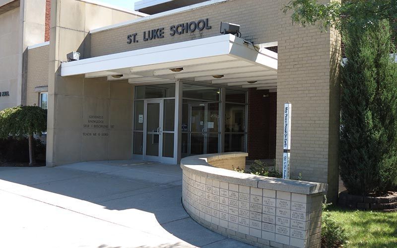 A st. luke school building with a white awning over the entrance