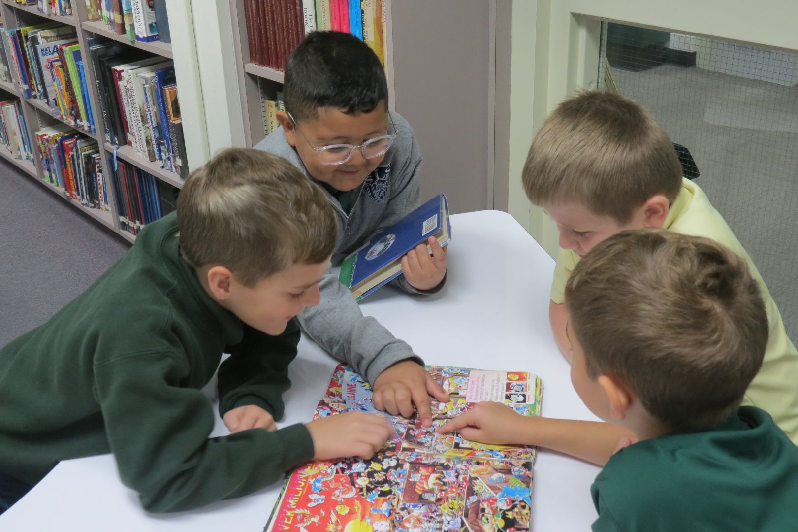 A group of young boys are reading a book together
