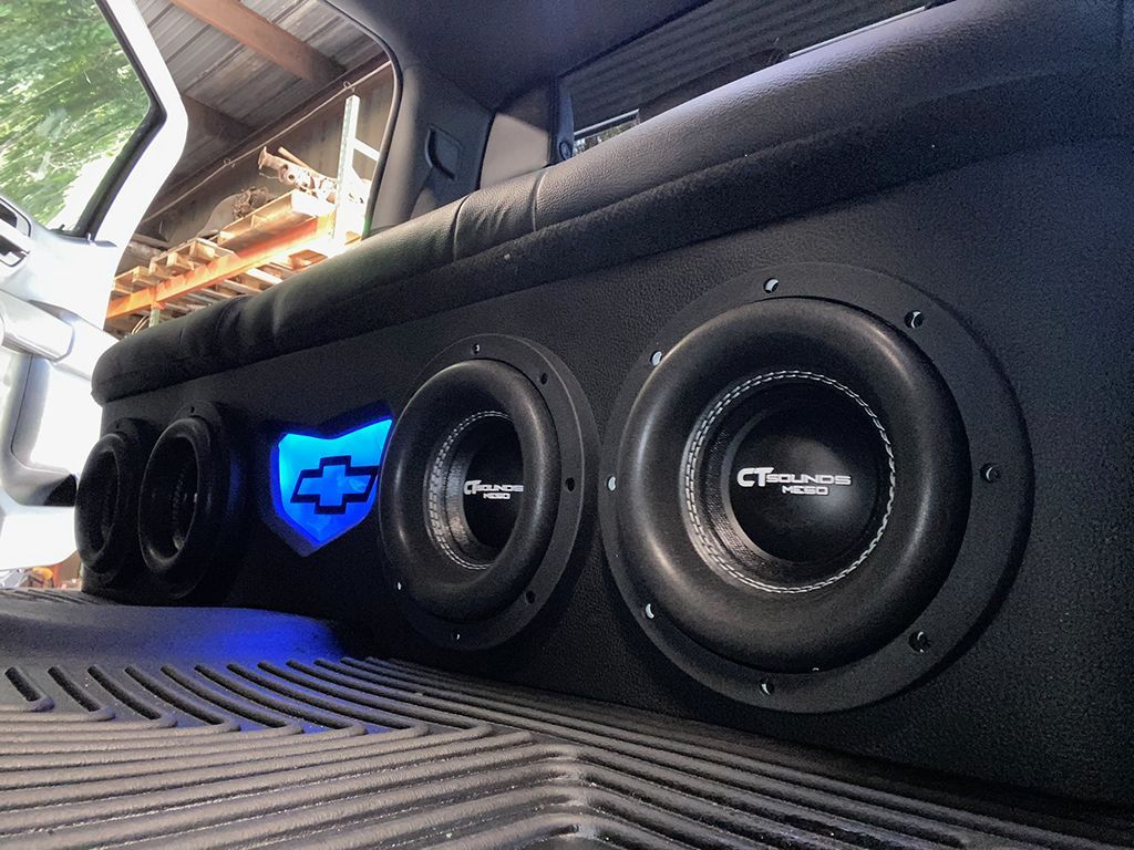 A car with a subwoofer in the back seat.
