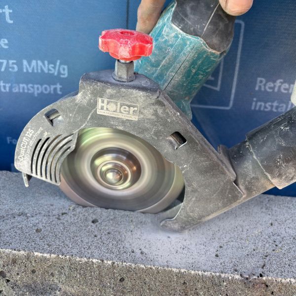 A person using a grinder tool to fit stone clip
