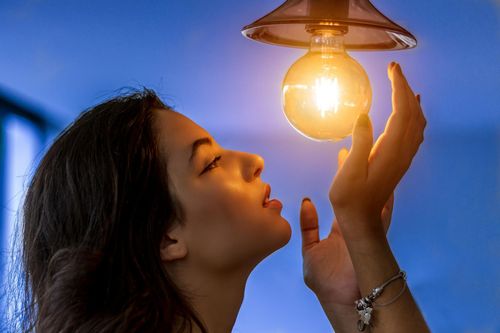 Homeowner changing light bulb - Big Bear Electric Pros lighting services