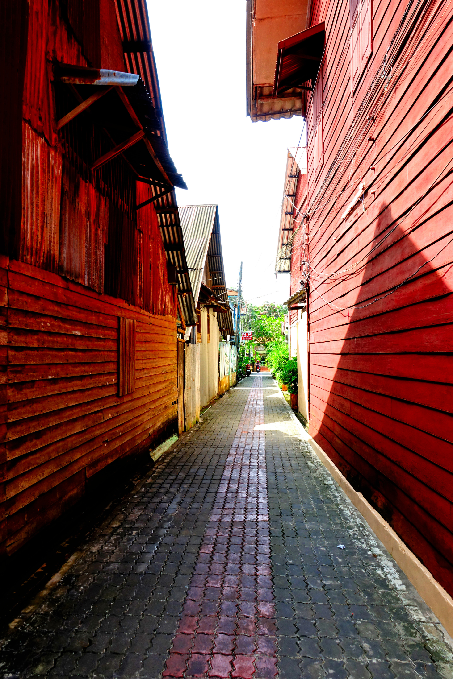 A narrow alleyway between two red buildings