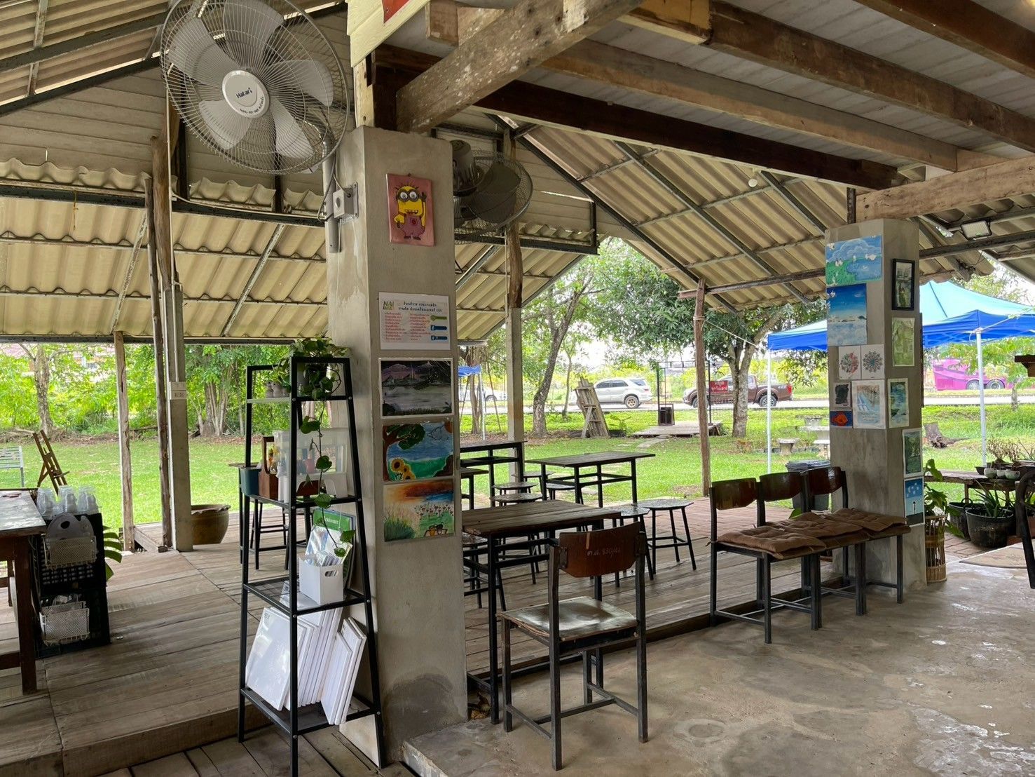 A restaurant with tables and chairs under a roof.