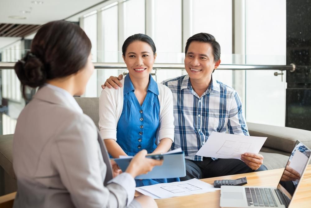 A Man and Woman Are Sitting at A Table Talking to A Woman — Twin Peaks Finance In Helensvale, QLD