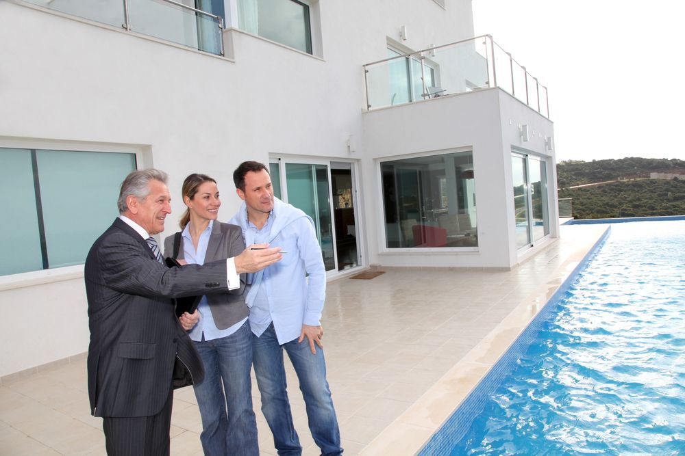 A realtor showing couple a house — Twin Peaks Finance In Helensvale, QLD