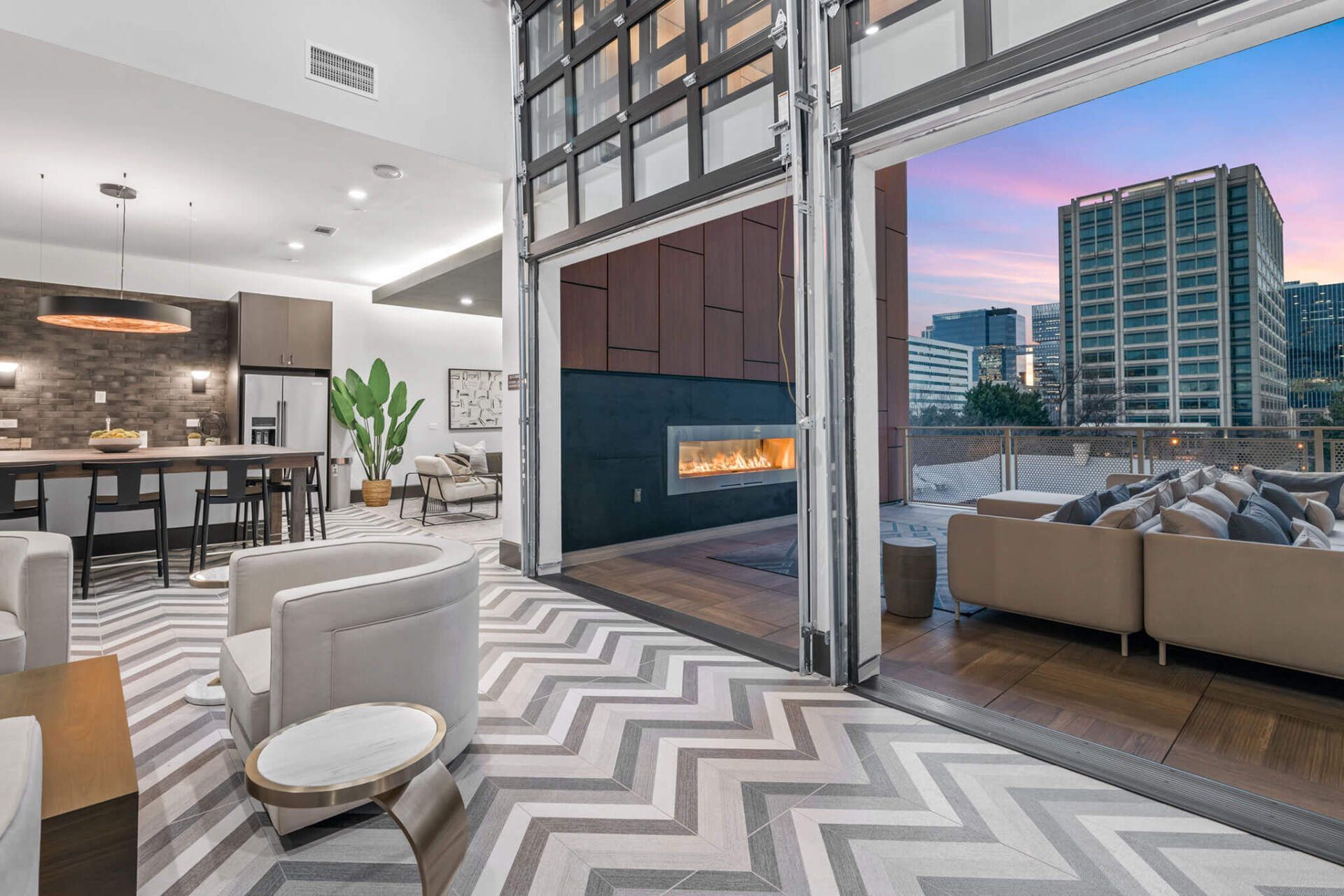 A living room with a fireplace , couch , chairs and a large window.