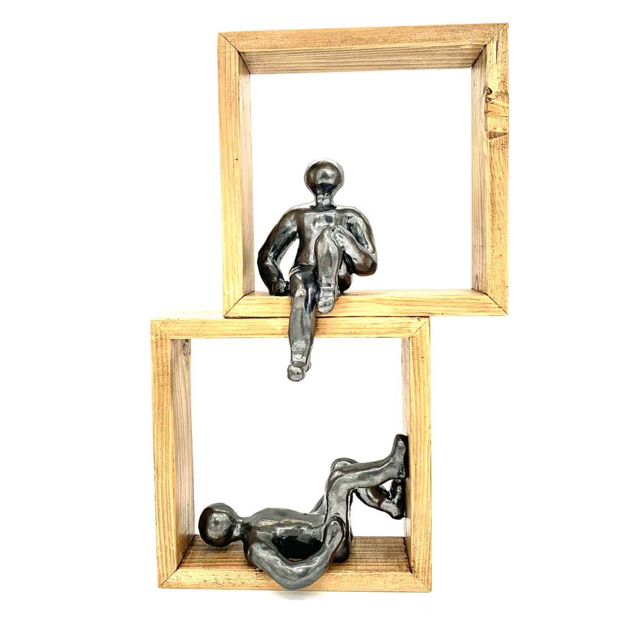 Twee houten lijsten met kleine zilveren figuurtjes erop en erin, op een witte achtergrond.