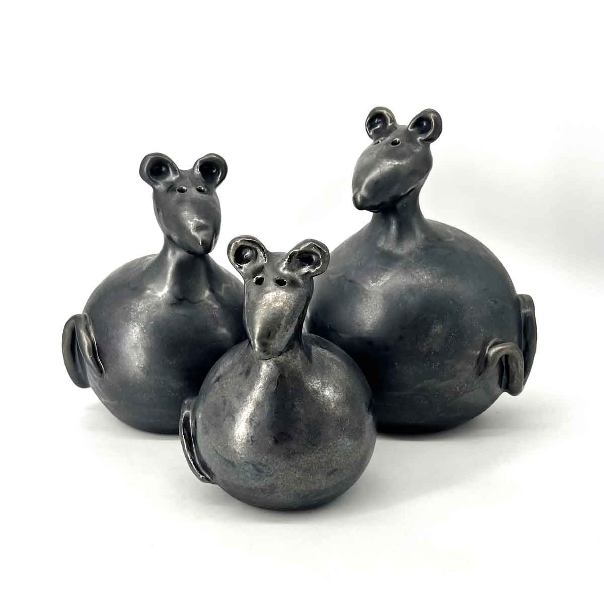 Drie zwarte muisvormige figuurtjes met ronde lijfjes en kleine oortjes op een witte achtergrond.