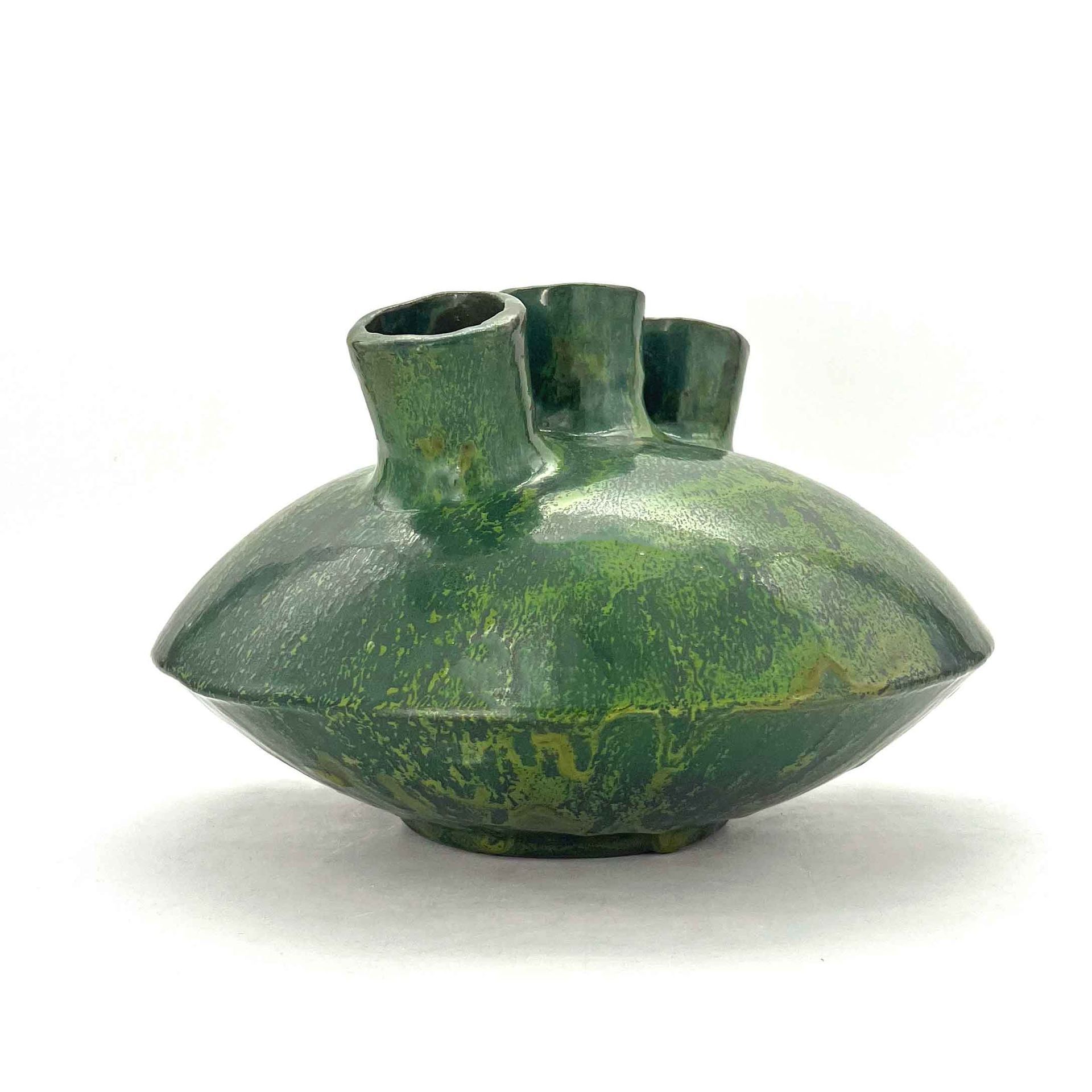 Groene keramische vaas met drie korte tuitjes op een witte achtergrond.