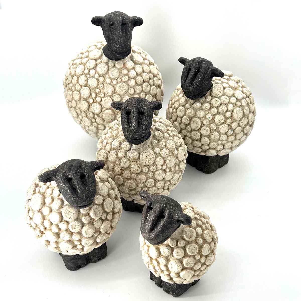 Vijf kleine schaapjes met zwarte koppen en poten op een witte achtergrond.
