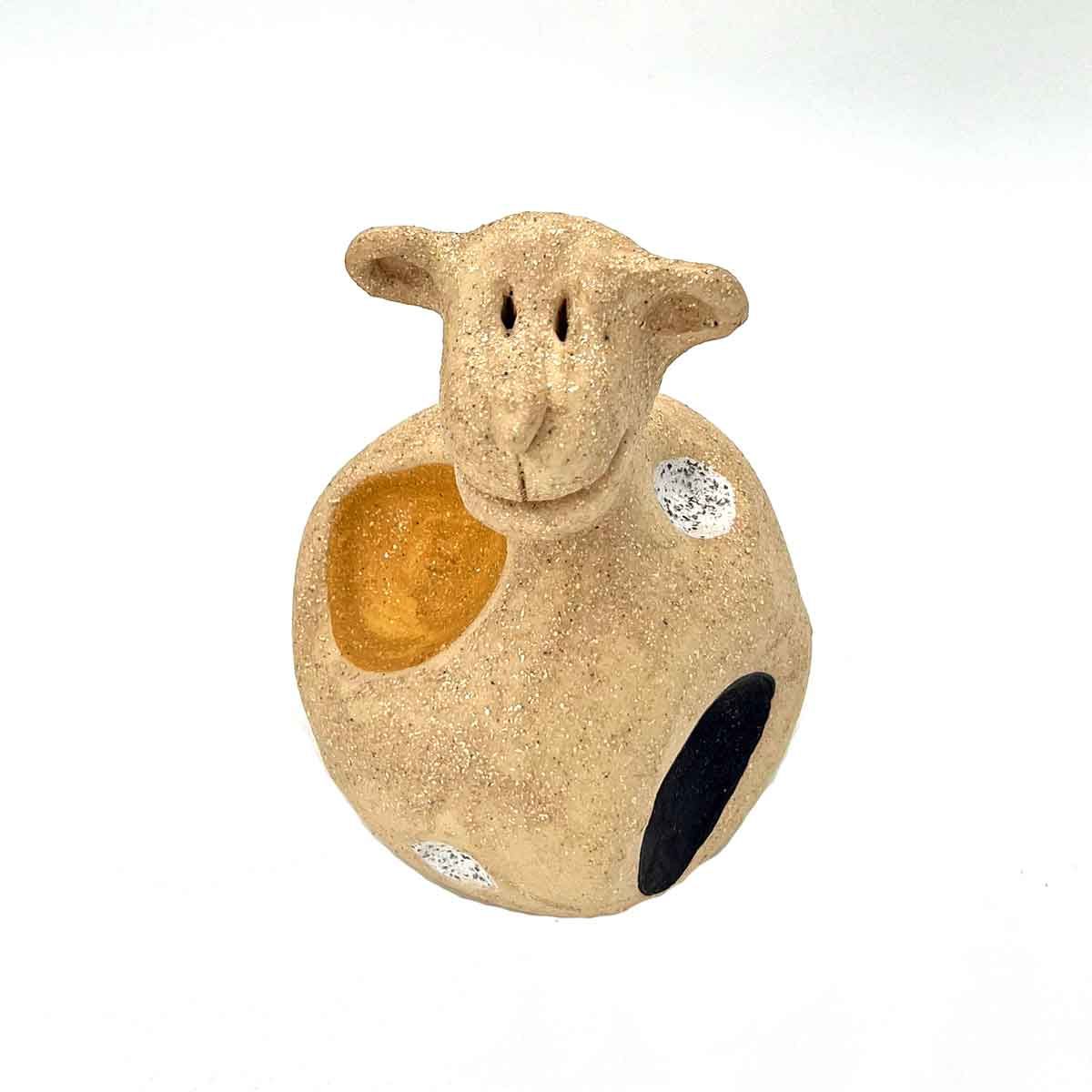Klein beige decoratief schaapje met geschilderde stippen op een witte achtergrond.