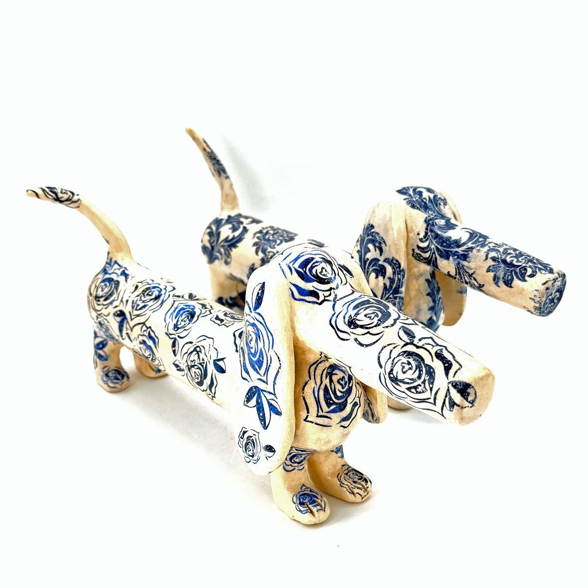 Twee blauw-witte keramische teckels met bloemenmotief.