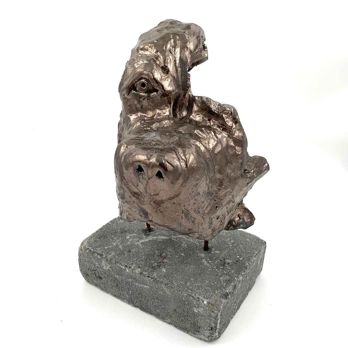 Abstracte bronzen sculptuur op een grijze stenen sokkel, bestaande uit twee op elkaar gestapelde ronde vormen met een gestructureerd oppervlak.