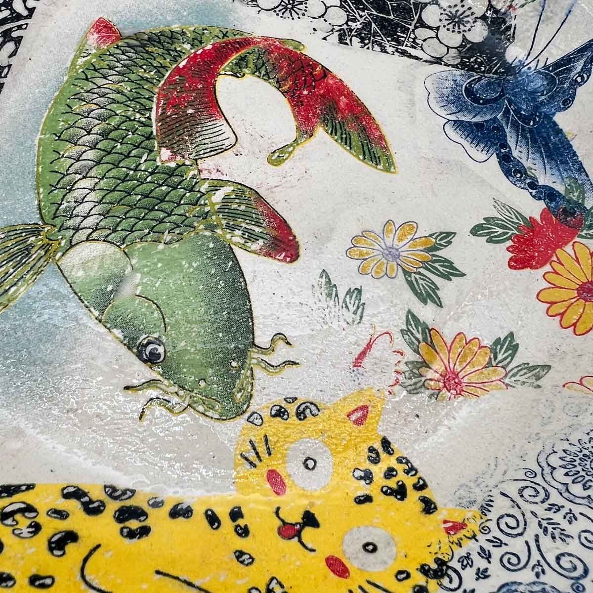 Kleurrijke vissen en bloemen op een bedrukte stof, met een gele luipaardvis op de voorgrond.