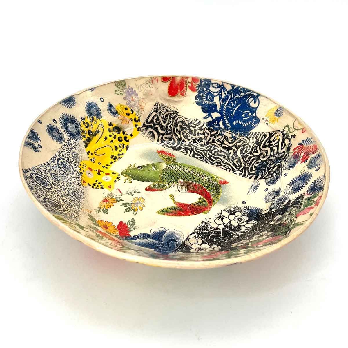 Kleurrijke decoratieve keramische kom met abstracte blauwe, gele, rode en groene patronen.