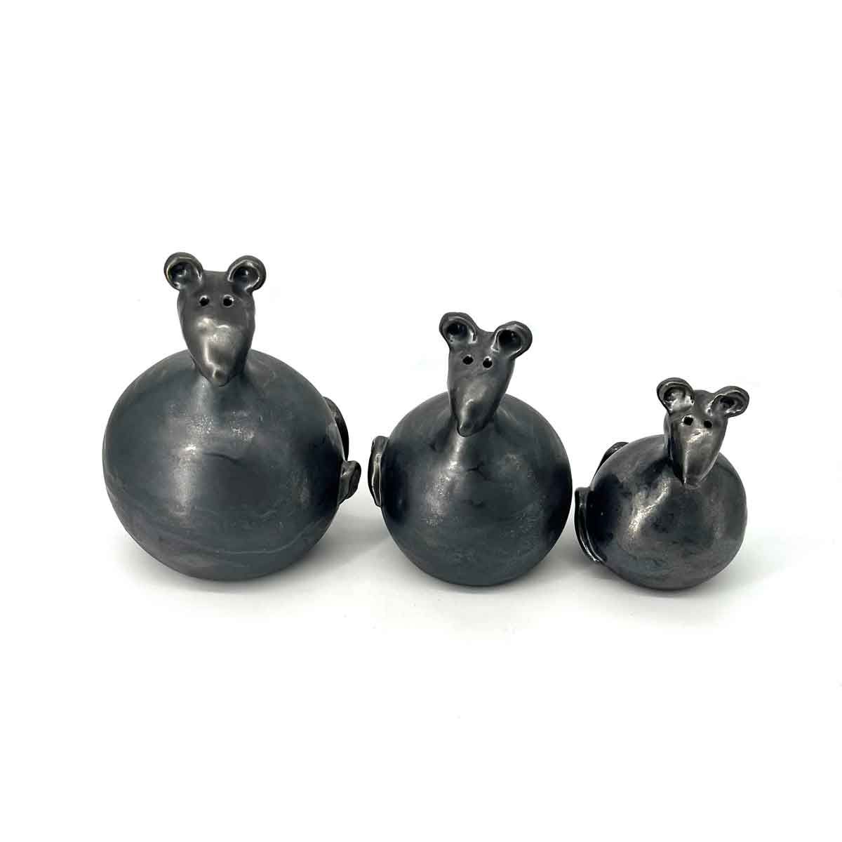 Drie kleine, donkere keramische muisjes met ronde lijfjes, gerangschikt op grootte op een witte achtergrond.