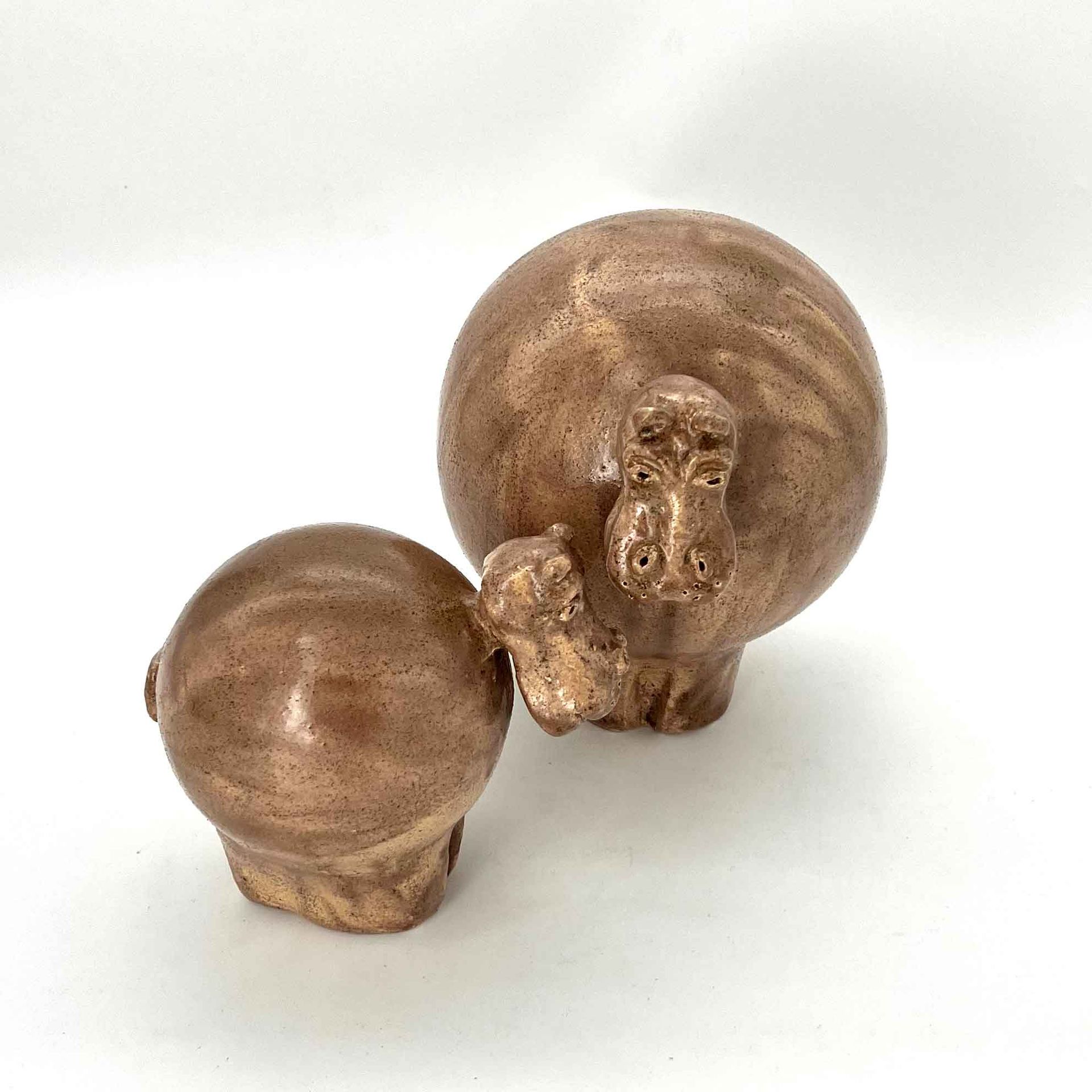 Twee kleine bruine houten beeldjes met afgeronde bovenkanten op een witte achtergrond.