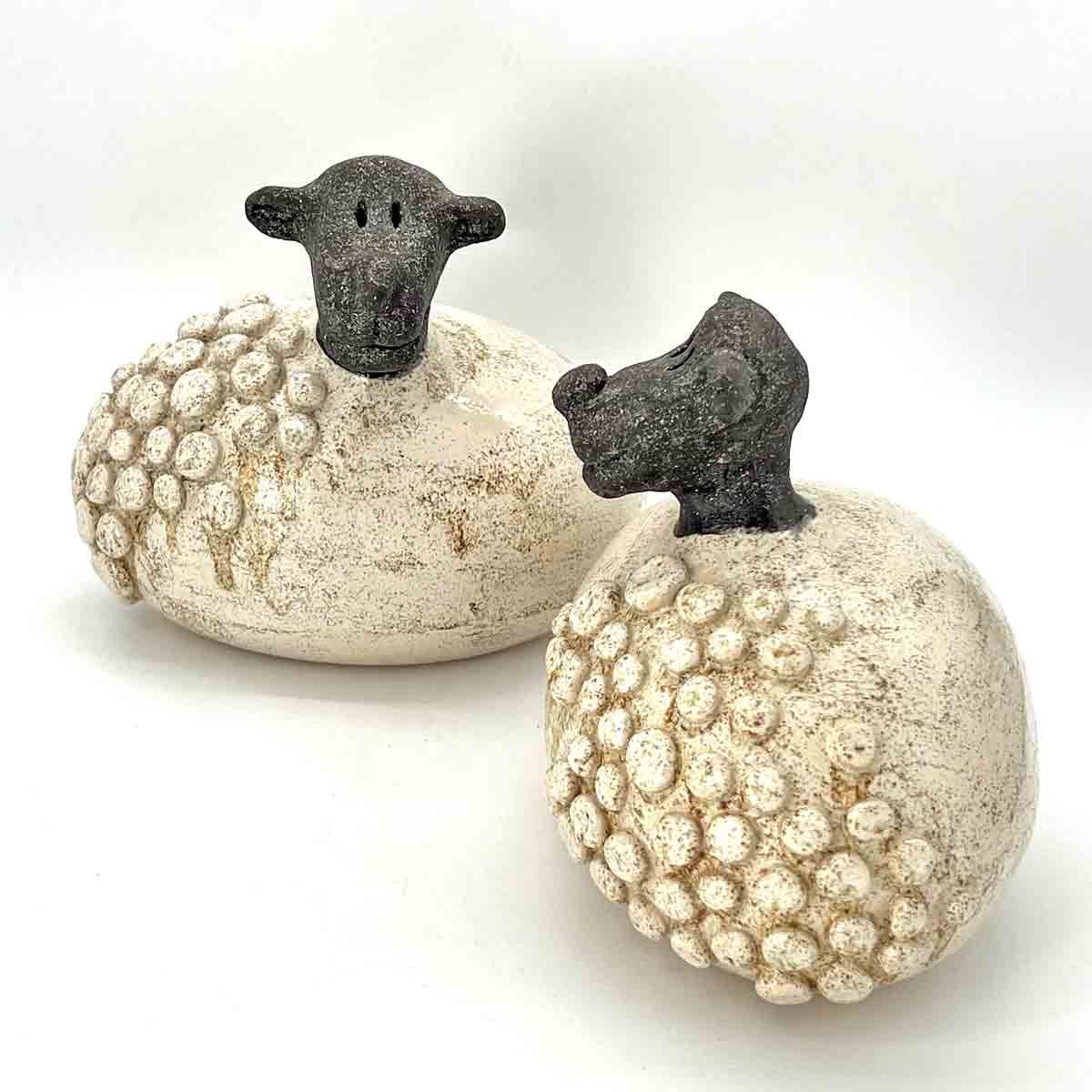Twee gespikkelde sierpompoenen met donkere stelen op een witte achtergrond.
